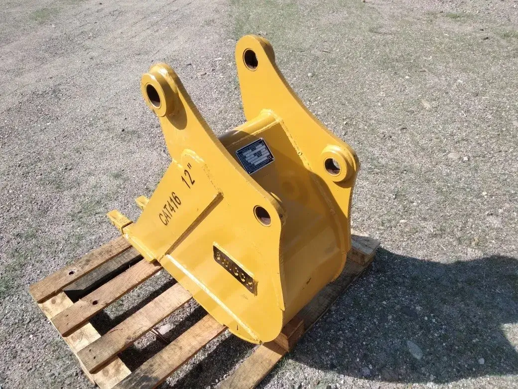 Bote cucharón SWICHH de 12 pulgadas acoplado a retroexcavadora Caterpillar en obra.
